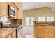 Kitchen with stainless steel range and microwave, granite countertops, and views of the living area at 8204 Turbys Treehouse Pl, Las Vegas, NV 89131