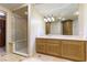 Bathroom featuring a glass shower, vanity with a sink and wooden cabinets for storage at 9101 Alta Dr # 301, Las Vegas, NV 89145