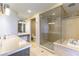 Spa-like bathroom with dual sinks, a vanity, a walk-in glass shower, and a separate soaking tub at 9101 Alta Dr # 301, Las Vegas, NV 89145