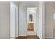 Hallway with hardwood floors, features a view of the bright bathroom with wood vanity at 9507 Brewing Cloud Ave, Las Vegas, NV 89148