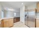 Open kitchen with stainless steel fridge, wood cabinets and breakfast bar at 9507 Brewing Cloud Ave, Las Vegas, NV 89148