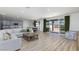 Bright, open-concept living space with wood-look floors, and a seamless transition to the dining and kitchen areas at 10095 Ferton Lake Ave, Las Vegas, NV 89178
