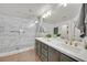 Bright bathroom featuring double sinks, modern lighting, and a marble walk-in shower at 10640 Amber Ridge Dr # 101, Las Vegas, NV 89144