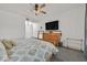 A well-lit bedroom with a dresser and a TV features a ceiling fan and carpet flooring at 10640 Amber Ridge Dr # 101, Las Vegas, NV 89144