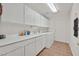 A functional laundry room features white cabinets, tile floors, and includes a sink and washer/dryer at 10640 Amber Ridge Dr # 101, Las Vegas, NV 89144