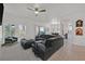 Bright living room featuring large windows, neutral walls, and a dark sectional sofa at 10640 Amber Ridge Dr # 101, Las Vegas, NV 89144