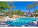 Stunning community pool with waterfall feature, lush landscaping, and comfortable lounge seating at 10640 Amber Ridge Dr # 101, Las Vegas, NV 89144