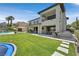 Spacious backyard with a pool, seating area, outdoor dining, and lush green lawn at 1404 Reisling Ct, Las Vegas, NV 89144
