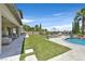 Expansive backyard featuring a pool with waterfall, lush lawn, and outdoor seating area at 1404 Reisling Ct, Las Vegas, NV 89144