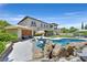 Backyard featuring a pool, spa, outdoor kitchen and dining area, and a covered seating area with views of the home at 1404 Reisling Ct, Las Vegas, NV 89144