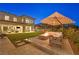 Evening view of the backyard highlighting the fire pit, seating area, and manicured lawn at 1404 Reisling Ct, Las Vegas, NV 89144