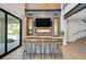Stylish bar area with seating, TV, wine storage, and easy access to the patio at 1404 Reisling Ct, Las Vegas, NV 89144