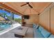 Outdoor cabana featuring a comfortable seating area with a television and views of the backyard pool and waterfall at 1404 Reisling Ct, Las Vegas, NV 89144