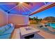 Covered cabana with a comfortable seating area, a fire pit, and views of the backyard pool at 1404 Reisling Ct, Las Vegas, NV 89144