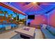 Outdoor cabana features comfortable seating with a television and a pool with a waterfall lit at night at 1404 Reisling Ct, Las Vegas, NV 89144