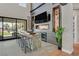 Modern living room with high ceilings, a wet bar, TV, custom wood details, and access to outdoor space at 1404 Reisling Ct, Las Vegas, NV 89144