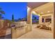 Night view of the covered patio with an outdoor kitchen and dining area, showcasing the inviting atmosphere at 1404 Reisling Ct, Las Vegas, NV 89144