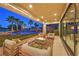 Covered patio features seating, a fire pit, and view of the pool with a waterfall feature in the evening at 1404 Reisling Ct, Las Vegas, NV 89144