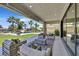 Stylish outdoor patio with comfortable seating around a modern fire pit, overlooking a lush backyard and pool at 1404 Reisling Ct, Las Vegas, NV 89144