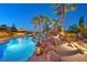 Stunning backyard pool with rock waterfall, palm trees, and ambient lighting creates a luxurious oasis at 1404 Reisling Ct, Las Vegas, NV 89144