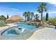 Backyard pool features a waterfall and two submerged lounge chairs with a tiki umbrella for relaxing in the sun at 1404 Reisling Ct, Las Vegas, NV 89144