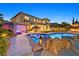 Backyard with a luxurious pool, lounge chairs, outdoor seating area, and well-manicured lawn at 1404 Reisling Ct, Las Vegas, NV 89144