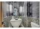Unique powder room featuring designer wallpaper, decorative lighting, a stylish vessel sink, and a modern toilet at 1404 Reisling Ct, Las Vegas, NV 89144