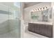 A full bathroom features a glass shower, a bath, and a double vanity with a large, well-lit mirror at 1761 Summerwood Cir, Henderson, NV 89012