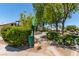 Community dog station with waste bag dispenser and trash can, surrounded by lush landscaping and mature trees at 1761 Summerwood Cir, Henderson, NV 89012