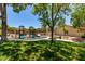 Community playground with slides and swings surrounded by mature trees and green spaces, ideal for outdoor play at 1761 Summerwood Cir, Henderson, NV 89012