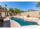 Backyard pool area features a stone waterfall and lush landscaping, creating a private oasis for relaxation and enjoyment at 1761 Summerwood Cir, Henderson, NV 89012