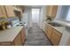 Galley kitchen with white appliances, wooden cabinets, and gray vinyl flooring at 2615 W Gary Ave # 2061, Las Vegas, NV 89123