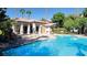 Community pool surrounded by lounge chairs and lush landscaping under a clear sky at 2615 W Gary Ave # 2061, Las Vegas, NV 89123