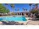 Inviting pool area with poolside lounge chairs, palm trees, and a clubhouse with desert plants at 2615 W Gary Ave # 2061, Las Vegas, NV 89123