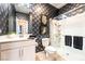 Modern bathroom featuring a shower with glass doors, black towel set, and designer wallpaper at 2845 Mincio St, Henderson, NV 89044