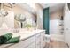 Bright bathroom featuring dual sinks, white cabinets, and a shower-tub combination with a green shower curtain at 2845 Mincio St, Henderson, NV 89044