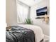 Bedroom with a wall-mounted television, shelving, a window, and neutral decor at 2845 Mincio St, Henderson, NV 89044