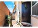 A welcoming front entryway with a black door, decorative wreath, and charming potted plants on a brick porch at 2845 Mincio St, Henderson, NV 89044