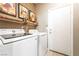 Bright laundry room features a side-by-side washer and dryer, decorative shelves, and convenient access to the backyard at 2845 Mincio St, Henderson, NV 89044