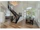 Bright entryway with hardwood floors, staircase, dining area and large chandelier at 2920 Sterling Cove Dr, Las Vegas, NV 89128