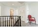 Hallway with carpet and built-in cabinets with black handrail, neutral walls, and a decorative chair at 2920 Sterling Cove Dr, Las Vegas, NV 89128