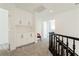 Hallway with built-in cabinets and black handrail, neutral walls, carpet and decorative chair at 2920 Sterling Cove Dr, Las Vegas, NV 89128