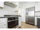 Modern kitchen featuring a built-in oven, cooktop, stainless steel refrigerator, and ample cabinet space at 2920 Sterling Cove Dr, Las Vegas, NV 89128