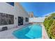 Sparkling backyard pool offers a refreshing escape, complemented by lush landscaping and clear skies at 3079 Evening Mist Ave, Henderson, NV 89052