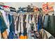 Walk-in closet with clothes on hangers, luggage, storage boxes and handbags on the floor at 3309 Green Ice Ave, North Las Vegas, NV 89081