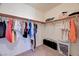 A walk-in closet with clothing on hangers and miscellaneous items on the upper shelf at 353 E Bonneville Ave # 313, Las Vegas, NV 89101