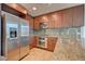 Close up of a modern kitchen featuring stainless steel appliances, granite countertops, and wood cabinets at 353 E Bonneville Ave # 313, Las Vegas, NV 89101
