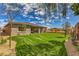 Manicured backyard with lush lawn, mature trees, and a well-maintained exterior, ideal for relaxation at 365 Sapphire Rock Ave, Las Vegas, NV 89183