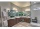 Bathroom with double sink vanity, decorative mirrors and tiles and a glass enclosed shower at 365 Sapphire Rock Ave, Las Vegas, NV 89183