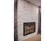 Close-up of a modern fireplace with a stone surround, hardwood floors, and sheer draperies at 4083 Nook Way # A, Las Vegas, NV 89103